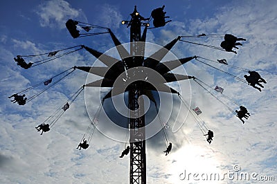 Silhouette of Towering Carnival Swing Ride Stock Photo