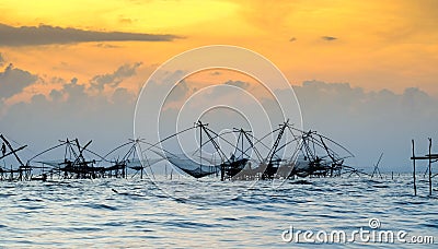 Silhouette of traditional fishing method using a bamboo square dip net with sunrise sky background Stock Photo