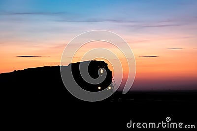 Silhouette of Train Engine Against Prairie Sunset Stock Photo