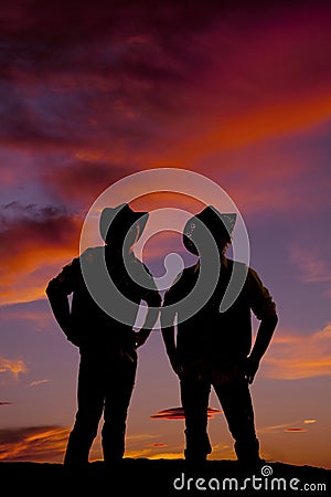 Silhouette of two cowboys standing in the sunset Stock Photo