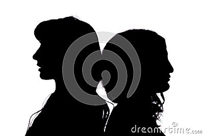 Silhouette. Two girls stand with their backs to each other on a white background. Stock Photo