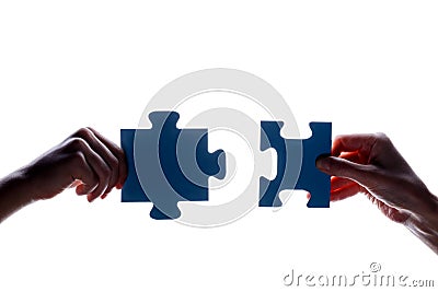 Silhouette of two hand holding couple of blue jigsaw puzzle piece on white background. concept - connection idea, sign, symbol, fr Stock Photo
