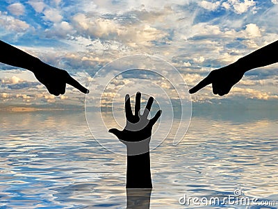 Silhouette of two hands showing a finger and condemning the hand of a sinking person asking for help Stock Photo