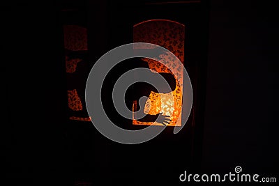 Silhouette of an unknown shadow figure on a door through a closed glass door. The silhouette of a human in front of a window at Stock Photo