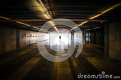 Silhouette of unrecognizable person and daylight ahead in subway tunnel Stock Photo