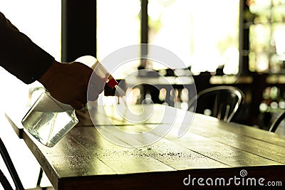 Silhouette waiter cleaning the table with disinfectant spray Stock Photo