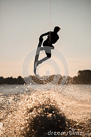 silhouette of wakeboarder jumping high making tricks in the air Stock Photo