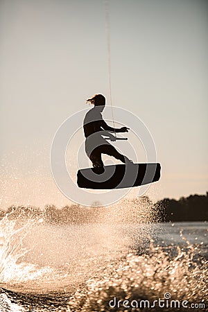 silhouette of wakeboarder skillfully jumping high making tricks in the air Stock Photo