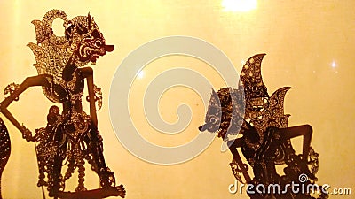 Silhouette Wayang kulit or puppet art from Java, Indonesia with orange light background Stock Photo