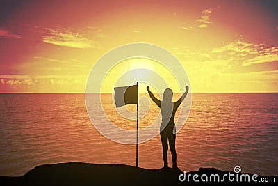 Silhouette of winning success woman at sunset or sunrise standing and raising up her hand near the flag in celebration Stock Photo