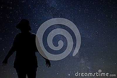 Silhouette of a woman against start night with the Milky Way band Stock Photo