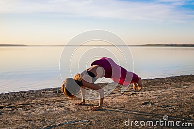 Silhouette yoga woman on the beach at sunset. Stock Photo
