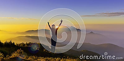 Silhouette of woman climb a peak of mountain hill at sunrise. Girl silhouette raise hand when trek on top mountain at sunset show Stock Photo