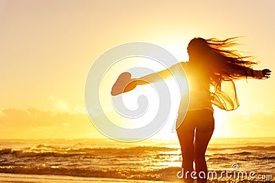 Silhouette of a woman dancing by the ocean Stock Photo