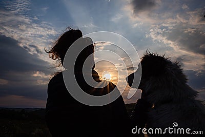 silhouette of woman and dog head at sunset pet teraphy Stock Photo