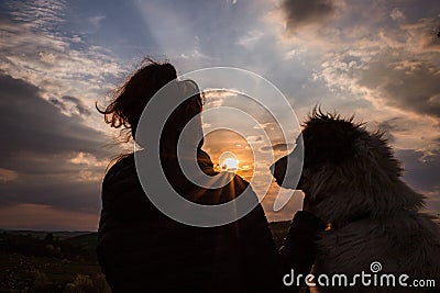 silhouette of woman and dog head at sunset pet teraphy Stock Photo