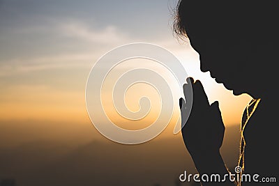 Silhouette of a woman Praying hands with faith in religion and belief in God On the morning sunrise background. Namaste or Stock Photo