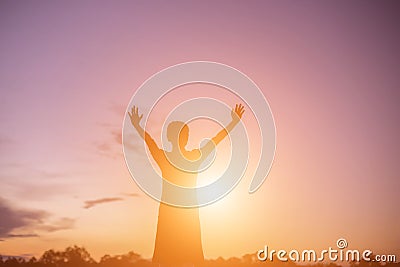 Silhouette of woman praying over beautiful sky background Stock Photo
