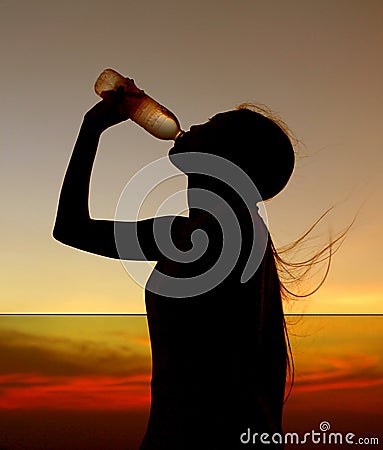 Silhouette of woman Rehydrate and refresh at sunset Stock Photo