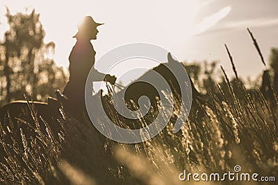 Silhouette of a woman riding a horse - sunset or sunrise Stock Photo