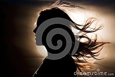 Silhouette of woman's head with waving hair, back light Stock Photo