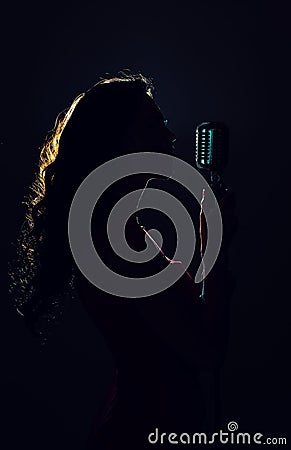 Silhouette of woman singing. Stock Photo