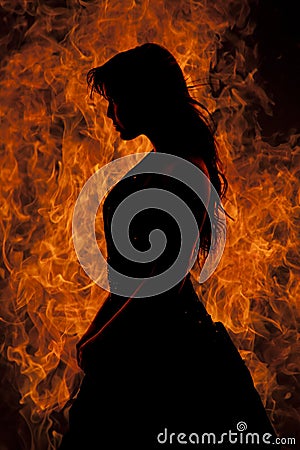 Silhouette woman stand in front of fire Stock Photo