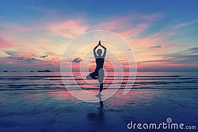 Silhouette of woman standing at yoga pose on the beach Stock Photo
