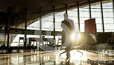 Silhouette of woman stucked at airport terminal over flight cancellation,calling family, sitting in almost empty airport Stock Photo