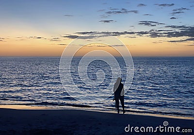Silhouette of woman wading on a Florida beach after sunset. Stock Photo