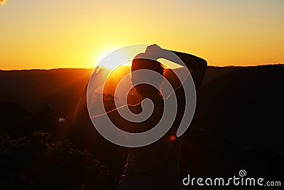 Silhouette of a woman watching the sunset Stock Photo