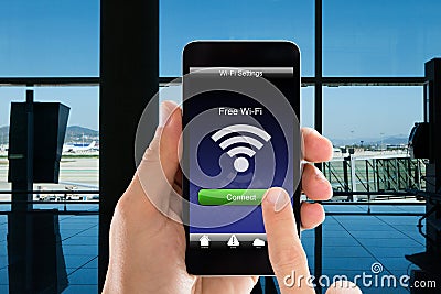 Person`s Hands Using Free WiFi On Smart Phone In Airport Stock Photo