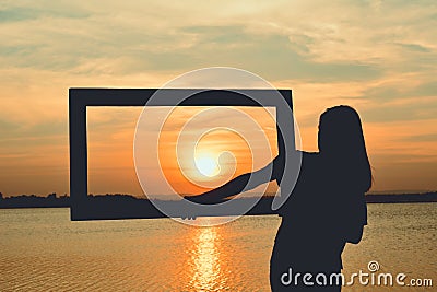 Silhouette of women holding frame Stock Photo