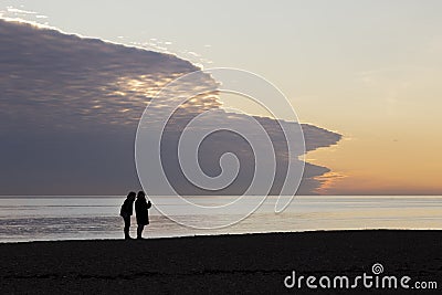 Silhouette of women talking on beach at Brighton Editorial Stock Photo