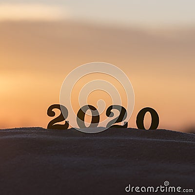 Silhouette of 2020 wooden numbers on the sand on the beach at sunset. Setting sun. The symbol of the outgoing year. 2021. Stock Photo