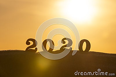 Silhouette of 2020 wooden numbers on the sand on the beach at sunset. Setting sun. The symbol of the outgoing year. 2021. Stock Photo