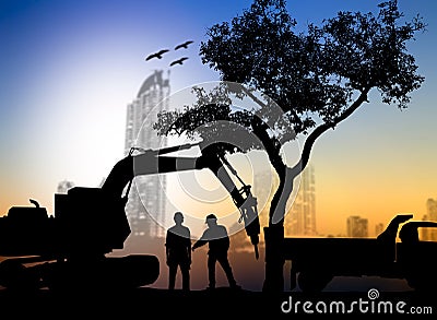 silhouette worker with Loaders and trucks in a building site over Blurred city Stock Photo