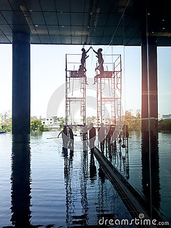 Worker on scaffolding cleaning window building Stock Photo