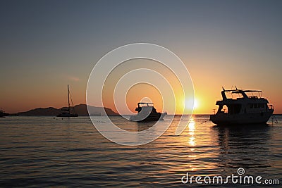 Silhouette yacht boat against the background of the sky of a sunny sunset. Silhouettes of ships on the background of the ocean and Stock Photo