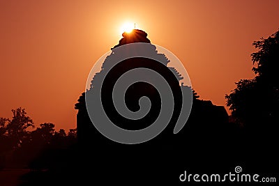 Silhouette of an Hindu temple as the sun rays emerge from behind. Sun Temple, Konark, Odissha (Orissa), India. UNESCO Stock Photo