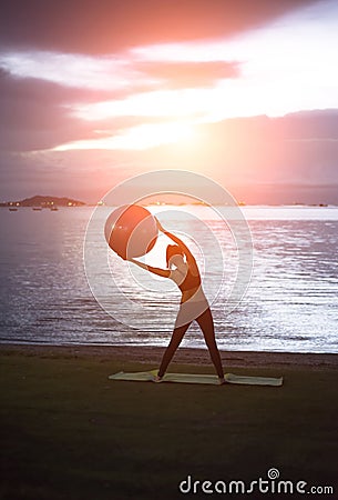 Silhouette yoga ball yung woman in the beach sunset Stock Photo