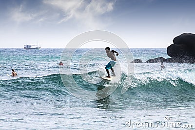 Silhouette young boy surfing on waves. Editorial Stock Photo