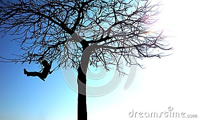 Silhouette of young girl on a swing Stock Photo