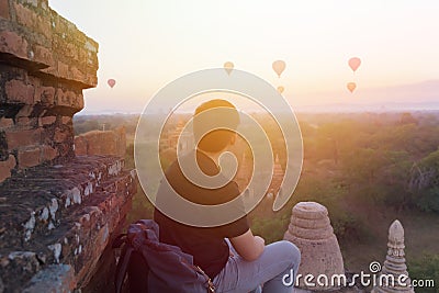 Silhouette of young male backpacker sitting and watching hot air balloon travel destinations in Bagan, Myanmar. Stock Photo