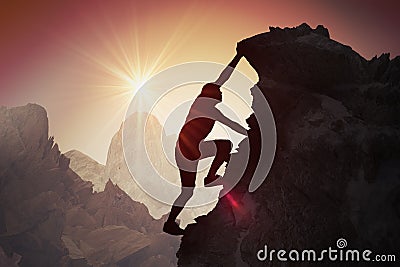 Silhouette of young man climbing on mountain Stock Photo