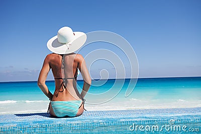 Silhouette of young woman on beach with hat Stock Photo