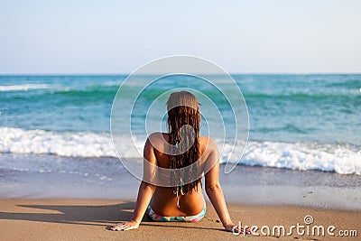 Silhouette of young woman on beach. young woman sitting in front of the seaside. Girl in bikini relaxing on the beach. Woman Stock Photo