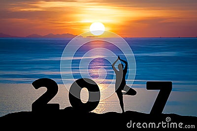 Silhouette young woman play Yoga on sea and 2017 years while celebrating happy new year Stock Photo