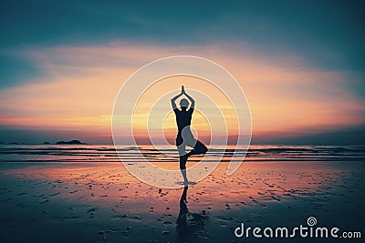 Silhouette young woman practicing yoga on the beach Stock Photo