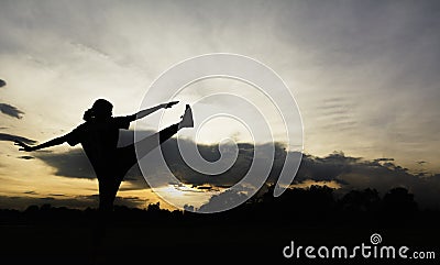 Silhouette of young woman practicing yoga outdoor. Female happiness. Sport and healthy concept Stock Photo